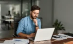 Distribuição de dividendos pode gerar autuação fiscal? Homem trabalhando em seu escritório usando notebook representando: Distribuição de dividendos pode gerar autuação fiscal?